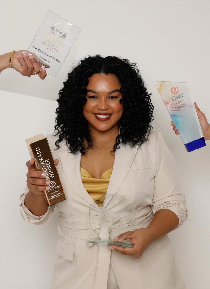 Kyomi Sayce holding her collection of industry awards